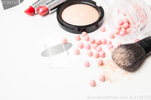 Image of the bronzing pearls, lipstick and makeup brush.