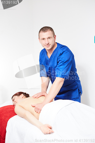 Image of Young woman having back massage.