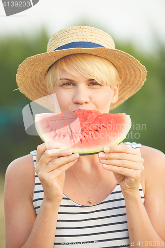 Image of Beautiful girl in straw hat eating fresh watermelon. Film camera style