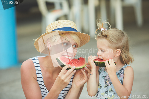 Image of Mother And Daughter Enjoying Slices Of WaterMelon