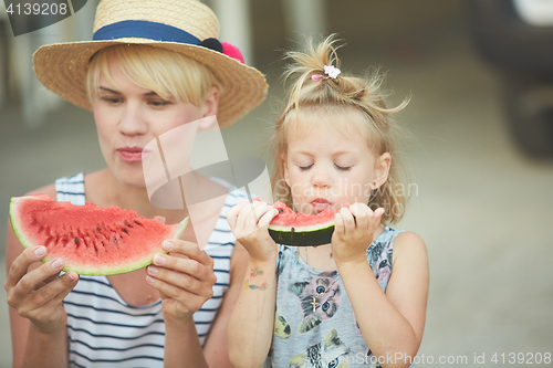 Image of Mother And Daughter Enjoying Slices Of WaterMelon