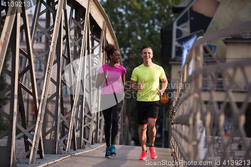 Image of multiethnic couple jogging in the city