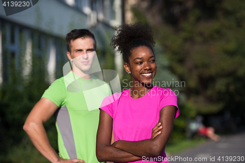 Image of portrait of young multietnic jogging couple ready to run