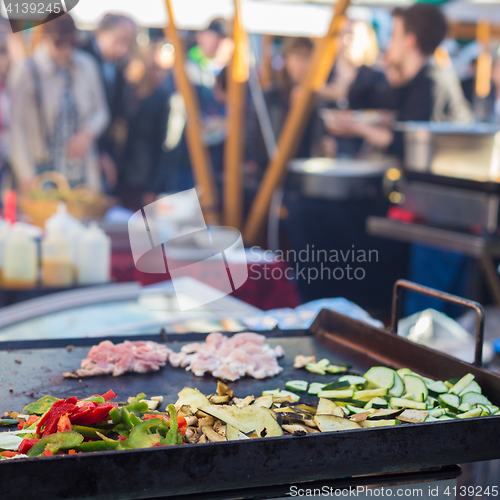 Image of Chef making chicken with grilled vegetable tortilla wrap outdoor on street stall.