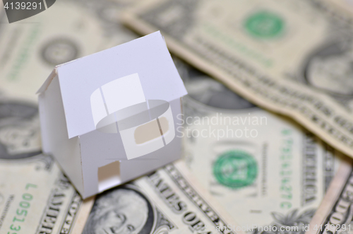 Image of Miniature paper made house stand on  money