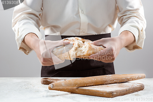 Image of The male hands and rustic organic loaf of bread