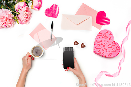 Image of The female hands with phone and gift box on white background