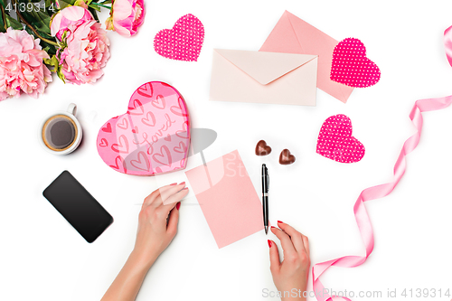 Image of The female hands with pen and gift box on white background