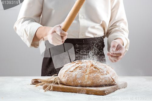 Image of The male hands and rustic organic loaf of bread