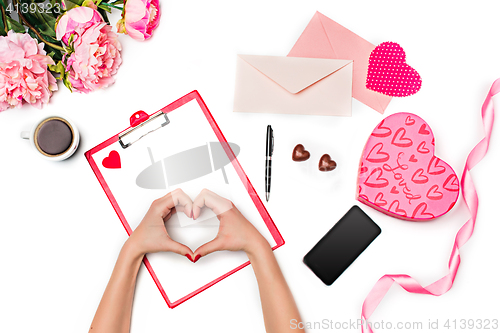 Image of The female hands making heart and gift box with hearts on white background