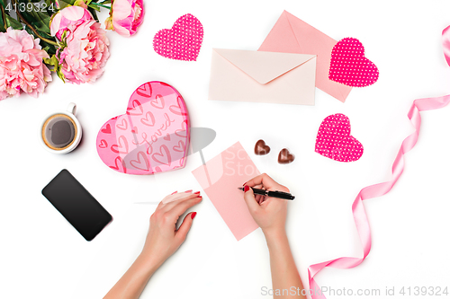 Image of The female hands with pen and gift box on white background