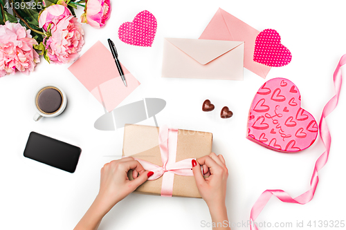 Image of The female hands with gift box on white background