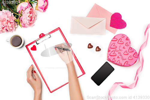 Image of The female hands with pen and gift box on white background