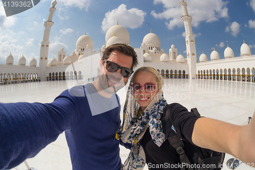 Image of Couple taking selfie in Sheikh Zayed Grand Mosque, Abu Dhabi, United Arab Emirates.