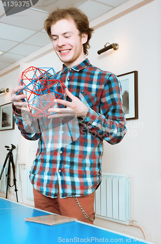 Image of Young Man Holding The Volumetric Model Of Geometric Solid