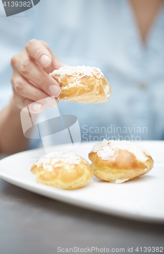 Image of Woman eating eclairs