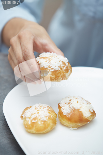 Image of Woman eating eclairs