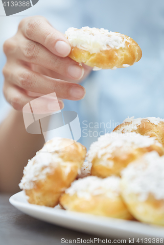 Image of Woman eating eclairs