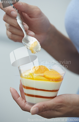 Image of Woman eating fruit mousse