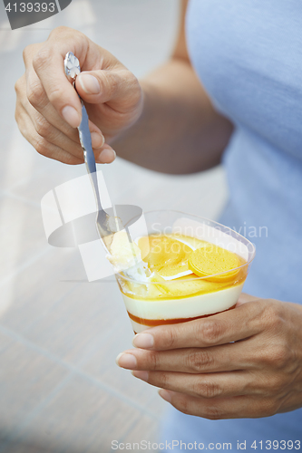 Image of Woman eating fruit mousse