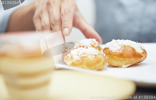 Image of Woman taking eclairs 