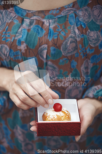 Image of Woman holding Christmas eclair