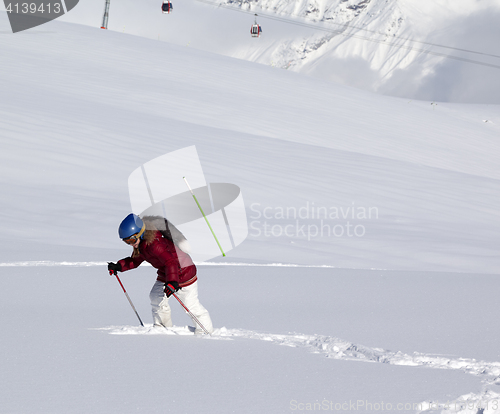 Image of Little skier on off-piste slope with new fallen snow at sun day