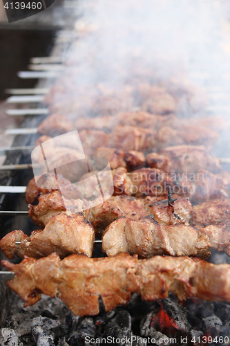 Image of Grilling marinated shashlik on a grill. Shish kebab popular in Eastern, Central Europe and other places. 