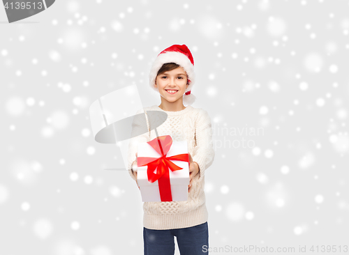 Image of smiling happy boy in santa hat with gift box