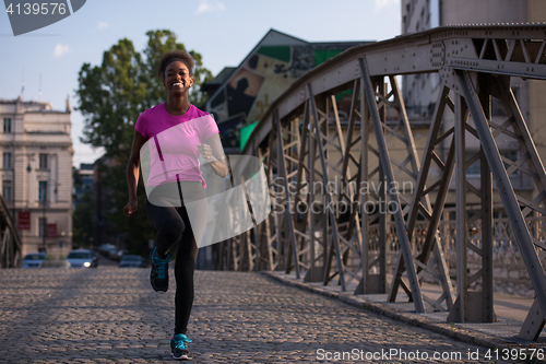 Image of african american woman running across the bridge