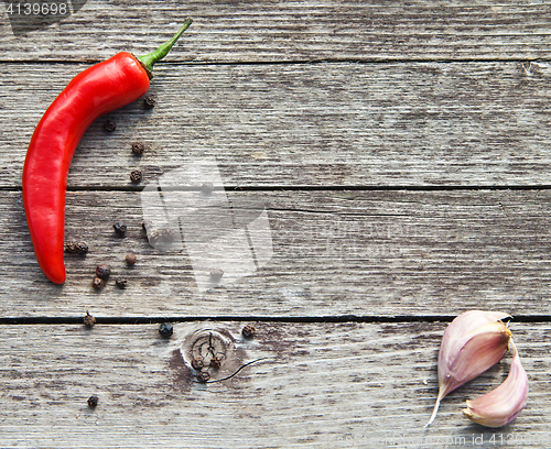 Image of Red hot chili peppers with garlic on wood