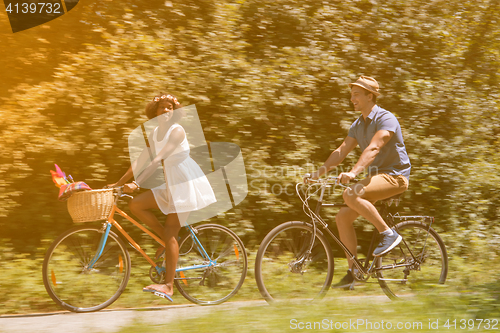 Image of Young multiethnic couple having a bike ride in nature