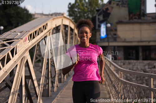 Image of african american woman running across the bridge