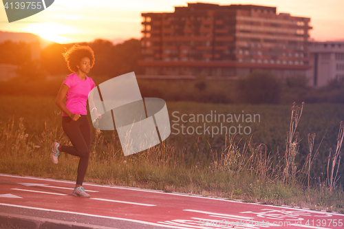 Image of a young African American woman jogging outdoors