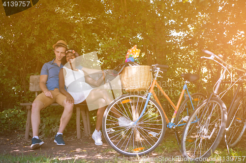 Image of Young multiethnic couple having a bike ride in nature