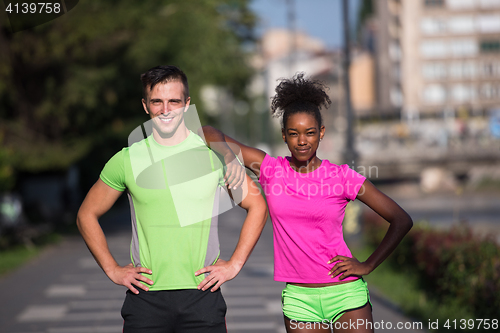 Image of portrait of young multietnic jogging couple ready to run