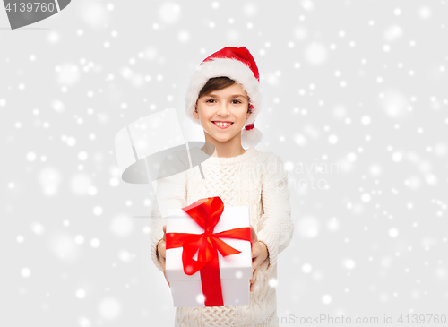 Image of smiling happy boy in santa hat with gift box