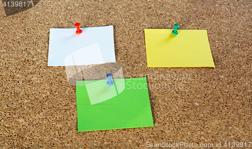 Image of Thumbtack pins and notepaper on pinboard