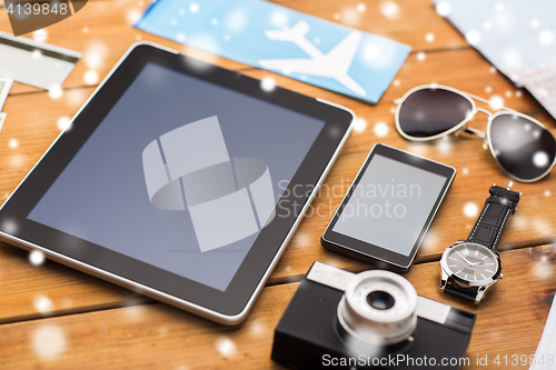 Image of tablet pc, smartphone, airplane ticket and camera