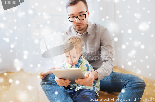 Image of father and son with tablet pc playing at home