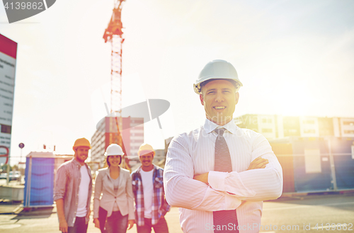 Image of happy builders and architect at construction site
