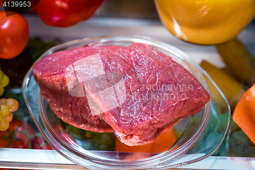 Image of Fresh raw meat on a shelf open refrigerator