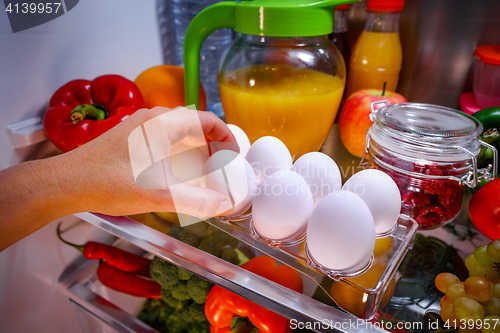 Image of Chicken eggs on a shelf open refrigerator