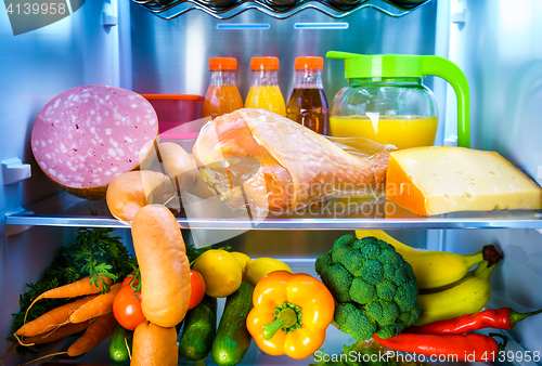 Image of Open refrigerator filled with food