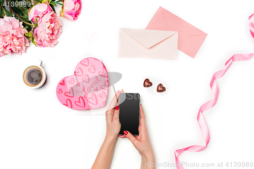 Image of The female hands with phone and gift box on white background