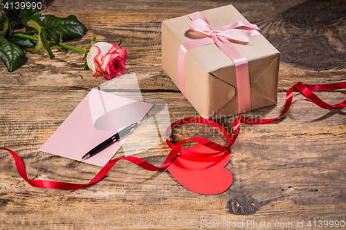 Image of The gift box with hearts on wooden background