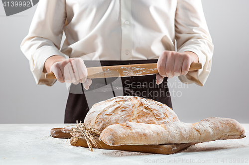 Image of The male hands and rustic organic loaf of bread