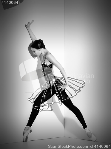 Image of Ballerina in black outfit posing on pointe shoes, studio background.