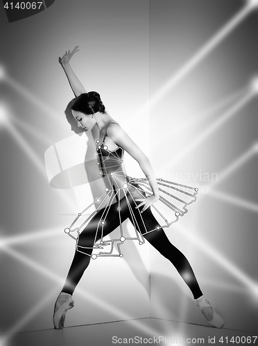 Image of Ballerina in black outfit posing on pointe shoes, studio background.