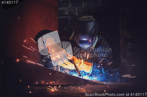 Image of worker welding metal